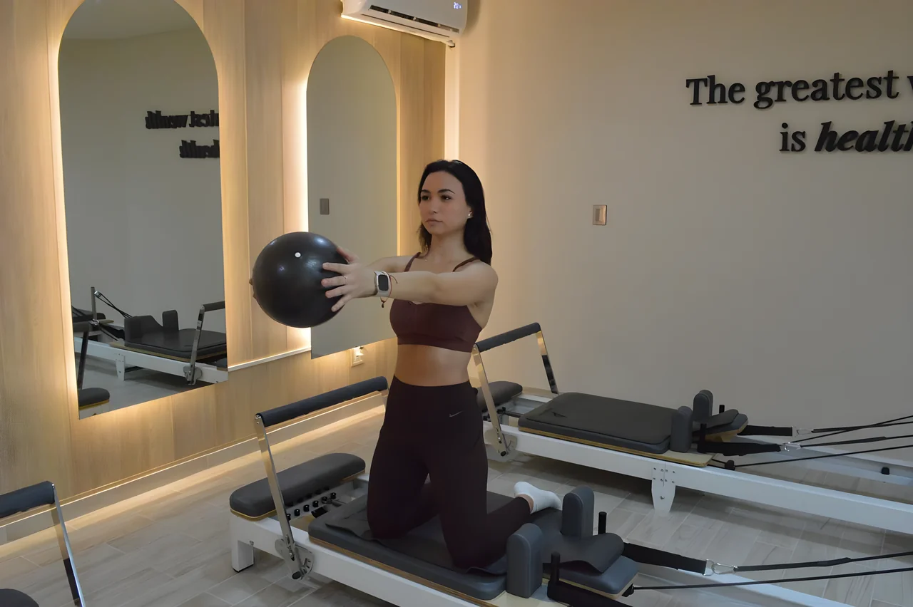 Instructora de Pilates con pelota de ejercicio en LÜMA Cancún